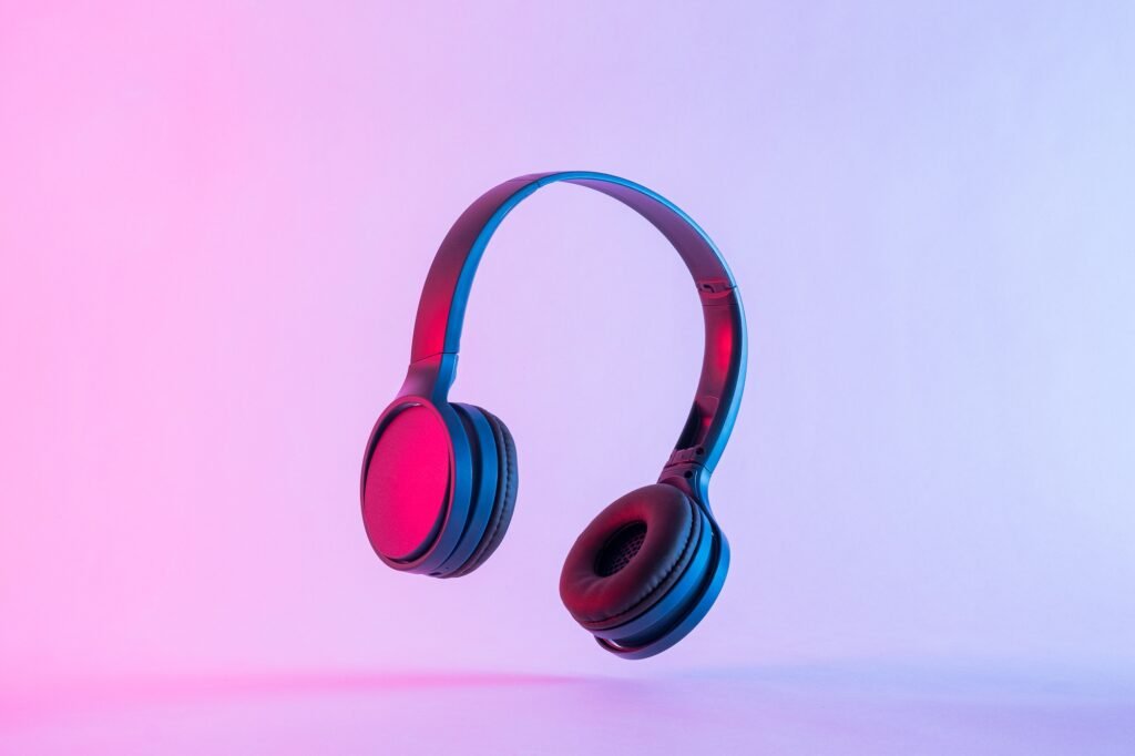 Contemporary headphones in neon night lighting at a party and modern stereo music technology.