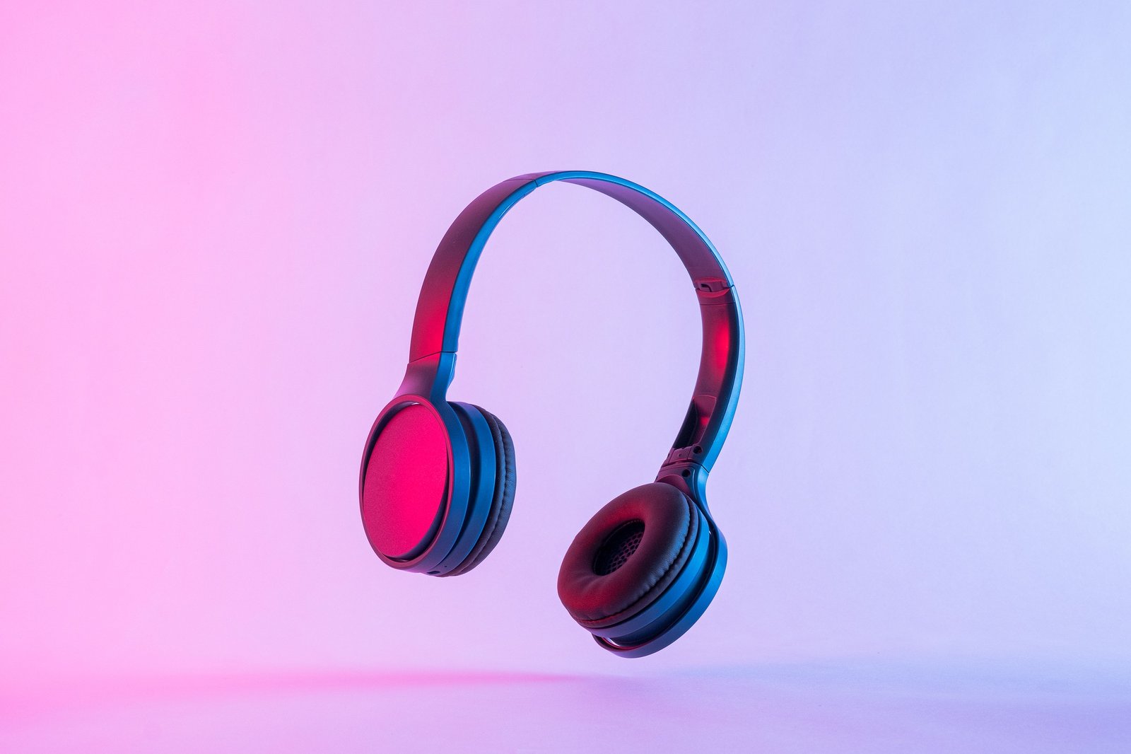 Contemporary headphones in neon night lighting at a party and modern stereo music technology.