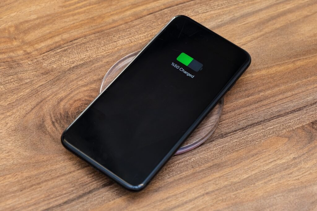 smartphone battery charging showing half charged battery on fast wireless charger concept